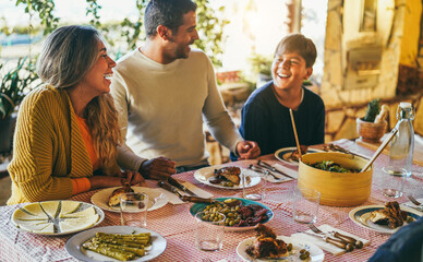 Happy latin family eating dinner together at home - Winter holidays and Christmas time concept -...