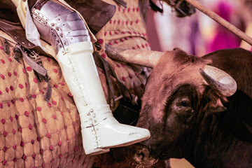 Bull charges at horse in Seville bullring during traditional bullfight