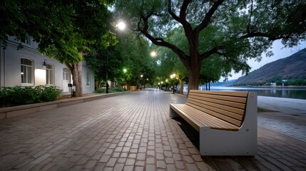 Empty paved walkway at dawn, lined with trees and light posts, overlooking a lake