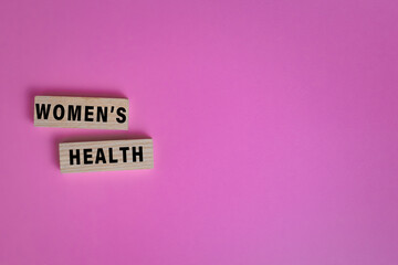 women health words text on wooden blocks isolated on pink background