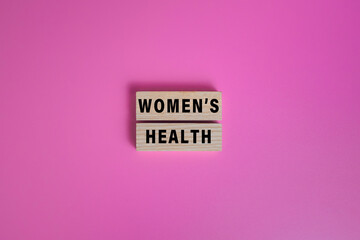 women health words text on wooden blocks isolated on pink background