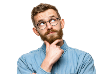 Thoughtful young man with beard and glasses in denim shirt looking up with hand on chin, isolated on white background