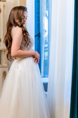 Fototapeta premium Romantic bridal portrait standing by vintage window on wedding day