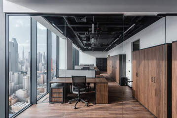 Loft open space office with wooden floor, modern furniture and panoramic windows. Bright open office with rows of desks and ceiling lighting