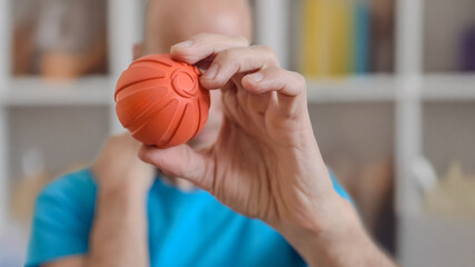 Man using small ball for neck and shoulder pain relief. Hand holding massage ball at home for...