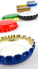 Colorful bottle caps in a row against white background