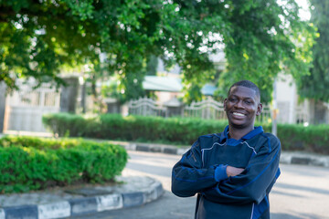 Confident young African man standing with arms crossed, isolated on white background. Concept of...