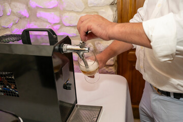 mains d'un homme se servant une bière sur une tireuse à bière lors d'une soirée