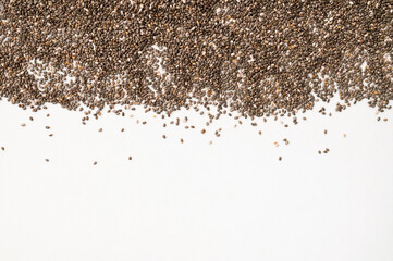 Dry chia seeds scattered on light gray white background top view. Food background, healthy eating concept, superfood. Healthy organic chia seeds rich in omega-3, protein, vitamins and minerals