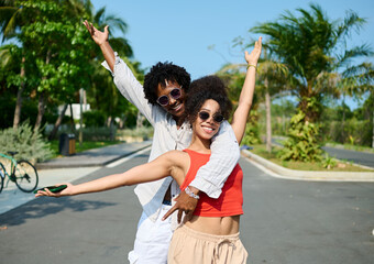 Portrait of a young couple at the beac in summertime,  a man and a woman are playing with a blue towel on the beach
