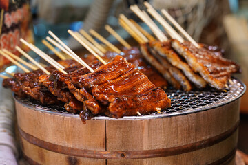 Glazed Meat Skewers on Wooden Sticks at Market. Japanese Street Food and Barbecue
