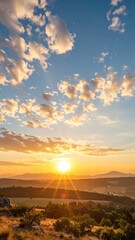 Sun rises over rolling hills and distant mountains, casting a warm golden glow across the landscape during a peaceful morning, creating a sense of serenity.
