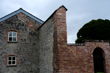 Fototapeta premium Classic brick masonry wall with artisanal craftsmanship in a serene outdoor environment near historical buildings