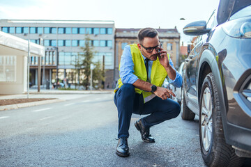 Business Professional Inspecting a Vehicle Issue While Talking on the Phone
