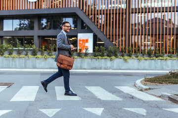 Business Professional Crossing Street with Briefcase Near Modern Office Building