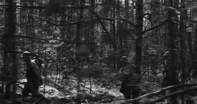 Historical Re-enactment Black And White Video. American Soldiers Of USA Infantry Of World War II Marching Running Run Along Forest In Autumn Spring Day. Group of soldiers