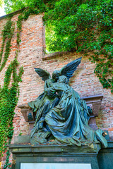 Ein großer Engel empfängt den Verstorbenen schöne Grabstätte vor eine Ziegelmauer Alter Südfriedhof München