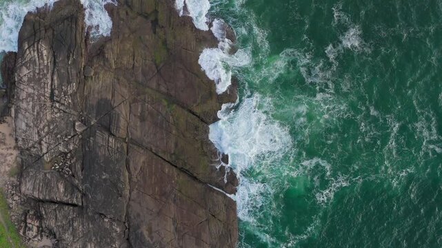 Evening Drone Push In over Rocky Cliff with White Foamy Sea Waves 