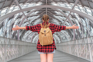 View of female tourist with backpack on a covered bridge
