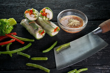 spring rolls with vegetables and tuna on a dark background with sauces and asparagus macro photo on a black background