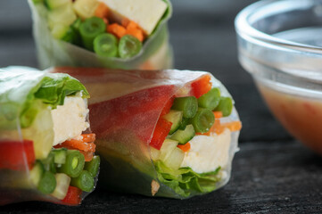 spring rolls with vegetables on a dark background with sauces macro photo on a black background