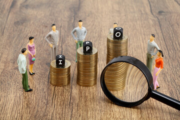 I P O blocks on stack of coins and magnifying glass - Concept of Initial public offering