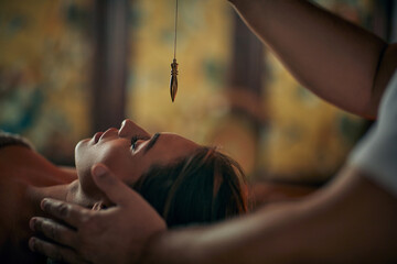 reiki therapist healing female in spa center with plumb line treatment