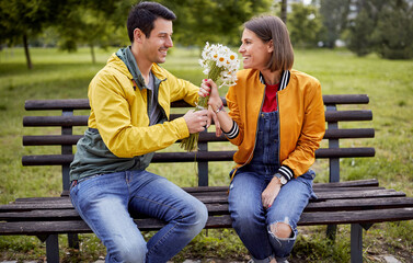 Man giving bouquet of flowers to a woman; Happy couple concept