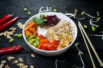 bibimbap with sprouts in a white plate on a dark charcoal background