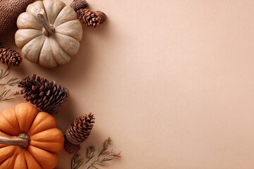 Autumnal flat lay border with pumpkins and pine cones on a neutral background.