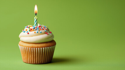 Single cupcake with lit candle on fresh green background, birthday theme. AI generated