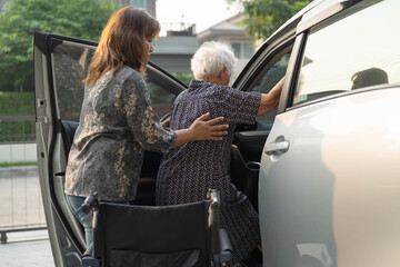 Caregiver help Asian elderly woman disability patient get in her car.