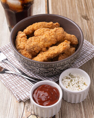 Breaded chicken bites in a plate over wooden table