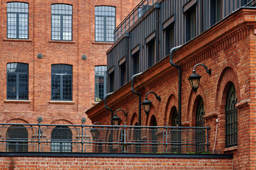 Historical brick facade undergoing renovation with scaffolding, showing layers of weathered and new bricks in Księży Młyn, Łódź © sebastiangora
