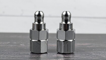 Two chrome metal parts on wooden surface