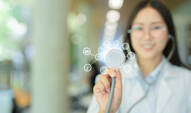 Female doctor in white coat holding hands with medical and healthcare icons.