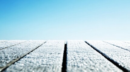 Close-up of frost-covered wooden planks with sparkling crystalline texture, rough surface, clear blue sky background,