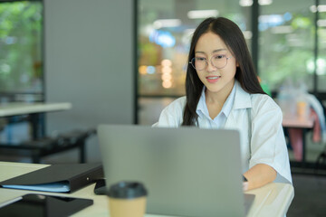 A female specialist doctor consults with a patient via laptop at a hospital.