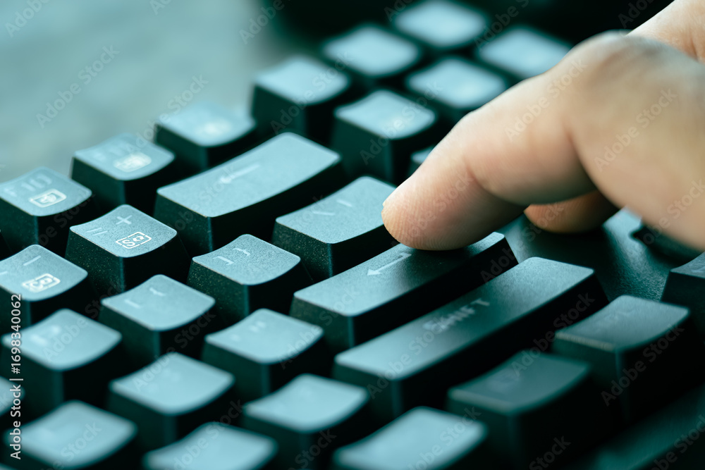 Poster close-up of a finger pressing the enter key on a black computer keyboard, symbolizing technology, co
