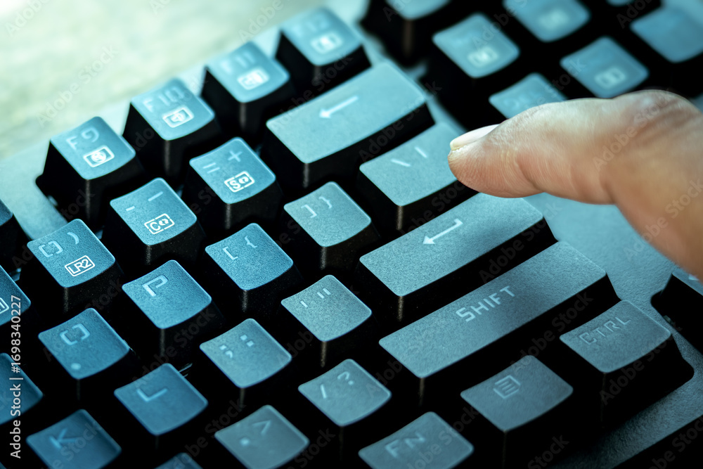 Poster close-up of a finger pressing the enter key on a black computer keyboard, symbolizing technology, co