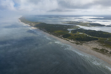 Clouds drift above the scenic Nauset Beach in Orleans, Cape Cod, Massachusetts. This aesthetic public beach is a popular destination for people on vacation during summer months. 