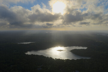 Beams of sunlight fall through low clouds illuminating Pilgrim Lake in Orleans on Cape Cod. This scenic Massachusetts peninsula harbors many ponds and lakes left over from the last glacial period.