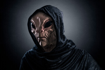 Mysterious humanoid alien at night over dark misty background. Silicone mask was used for this photo, no AI.