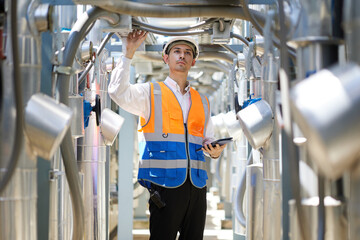 Engineer or technician looking above and checking air conditioner control valve at plumbing systems