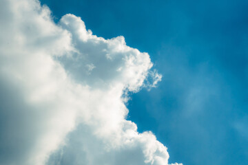 White fluffy cloud in clear blue sky, minimal natural background for design, concept, and relaxation themes.