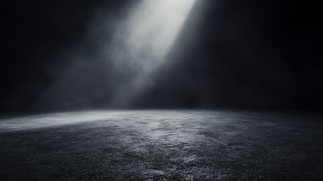 Moody spotlight illuminates dark asphalt floor