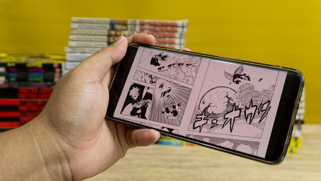Kalimantan Selatan, Indonesia - 09 11 2025 : Person reading Boruto manga digitally with stack of Japanese comic books in background, highlighting modern comic culture.