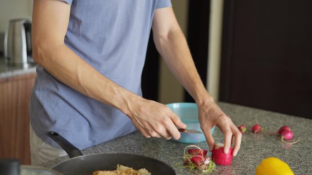 A young man is cooking food in the kitchen, focusing on preparing a delicious homemade meal. A relatable and warm moment of homemaking, creativity, and culinary enjoyment in a cozy setting.