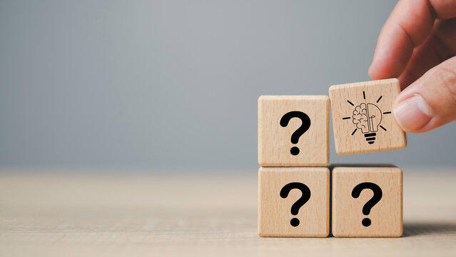 Questions and answers concept with wooden blocks showing question marks and brain light bulb icon, symbolizing problem solving, idea generation, and finding innovative solutions.