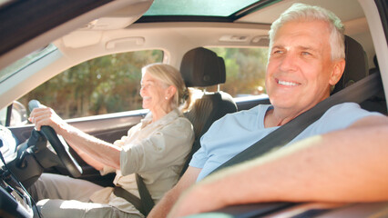 Senior Couple In Car With Map Arguing About Directions On Day Trip Out